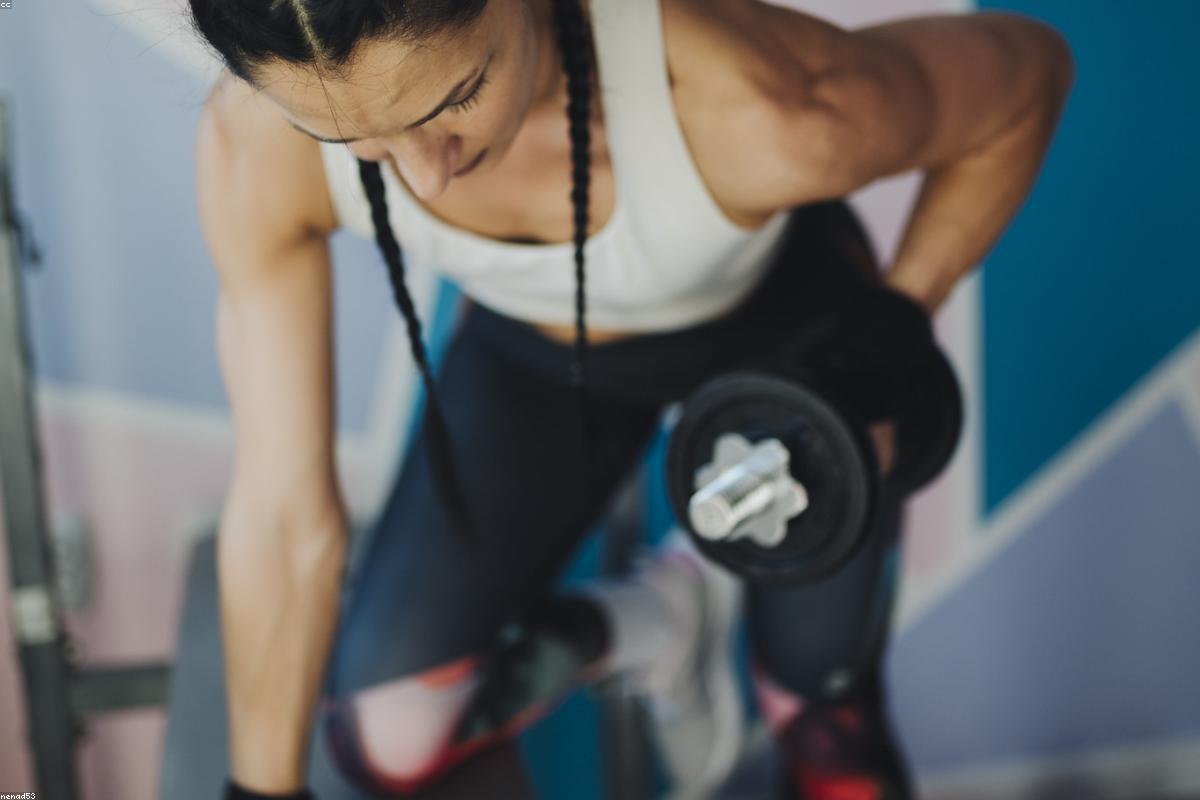 Machine guidée de musculation avec plaques de charge dans une salle équipée